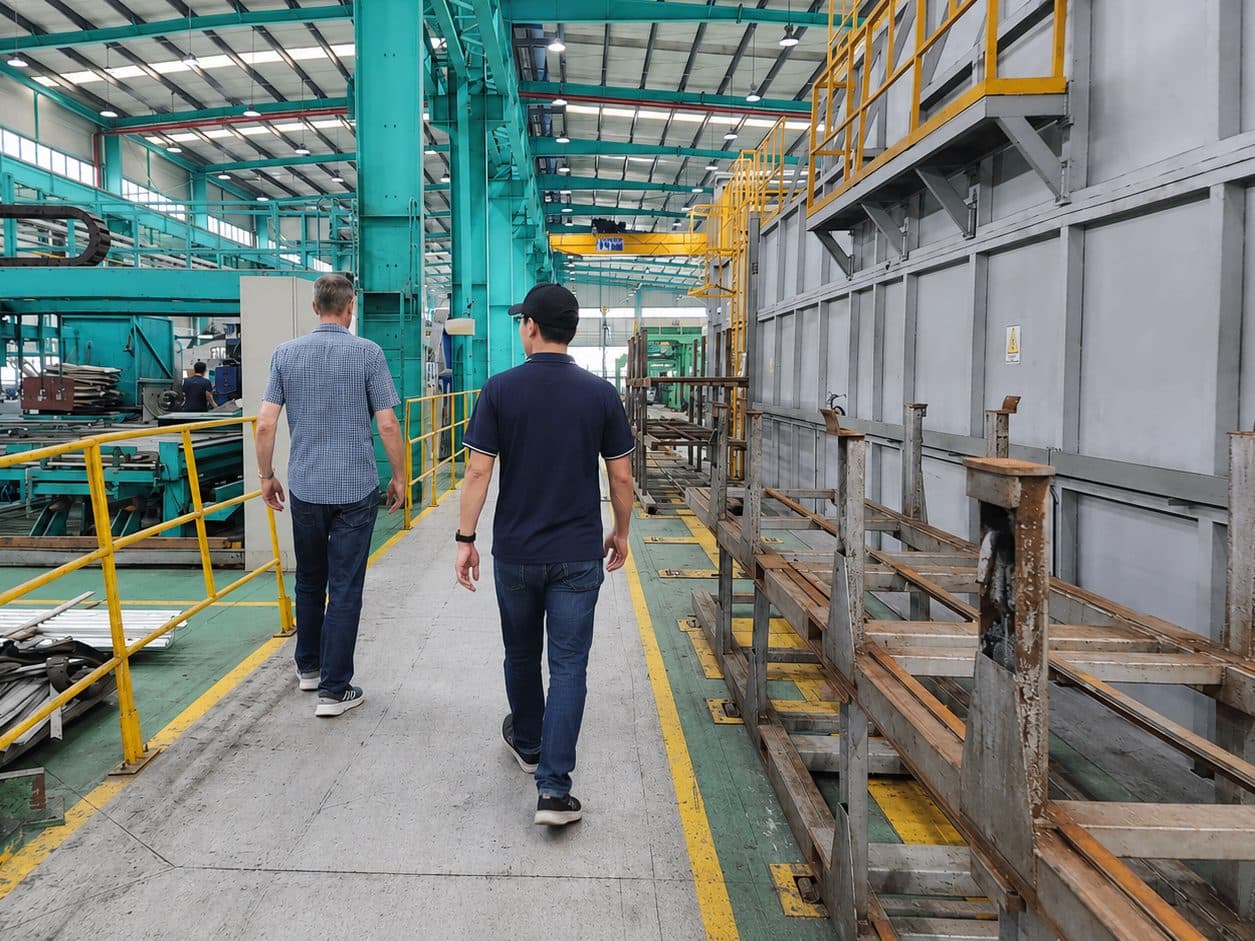 Two people walking through an industrial manufacturing plant